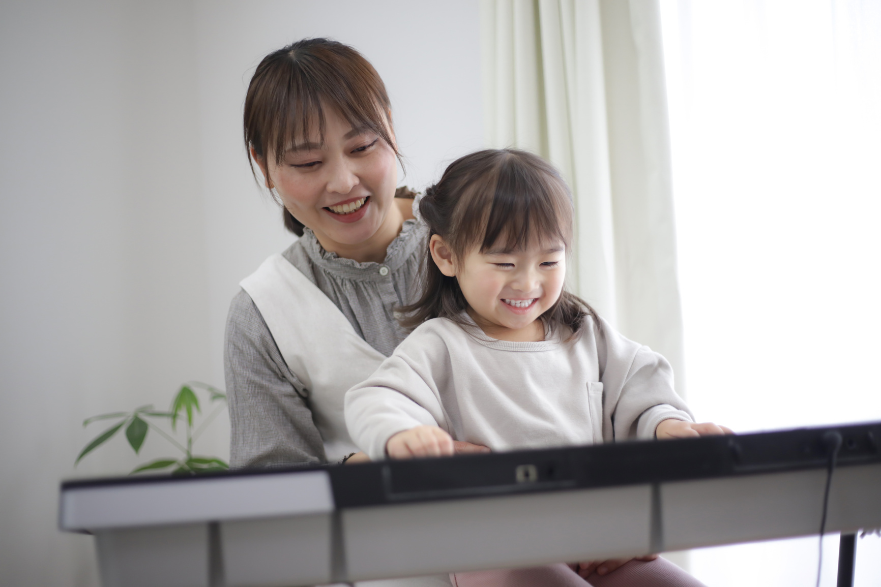 Parents and children practicing playing the piano